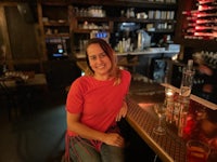 a woman sitting at a bar with a glass of wine