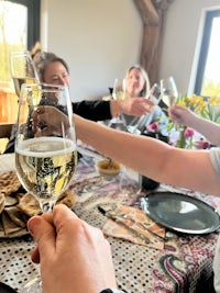 a group of people toasting with wine glasses at a table