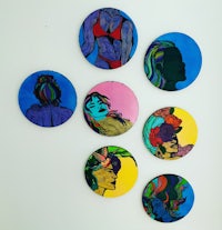 a group of colorful round plates with a woman's face on them