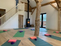 a large room with yoga mats and a fireplace